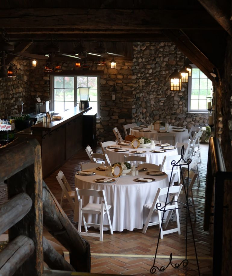 Tables and chairs set up around a decorated tavern at Castle Farms.
