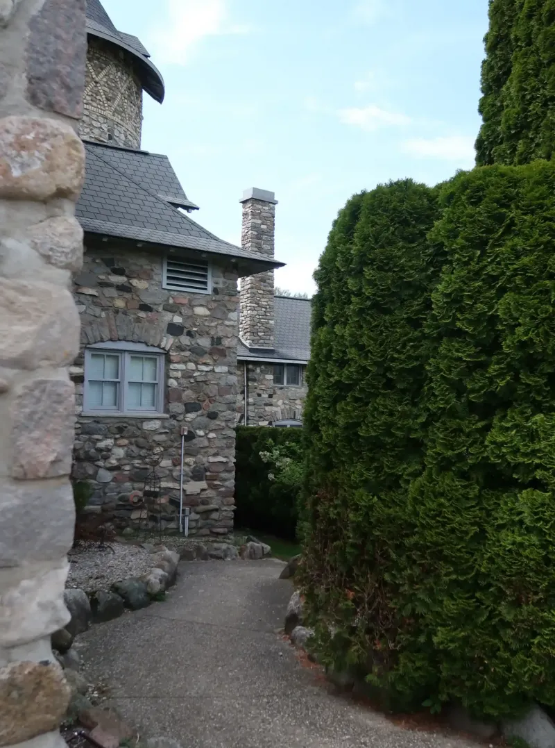 A gravel path winding through the stone buildings and shaped hedges of Castle Farms.