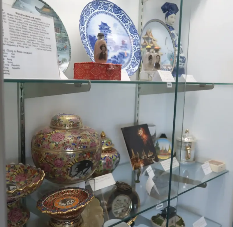 A glass case of old pots and ceramic plates at a museum in Castle Farms.