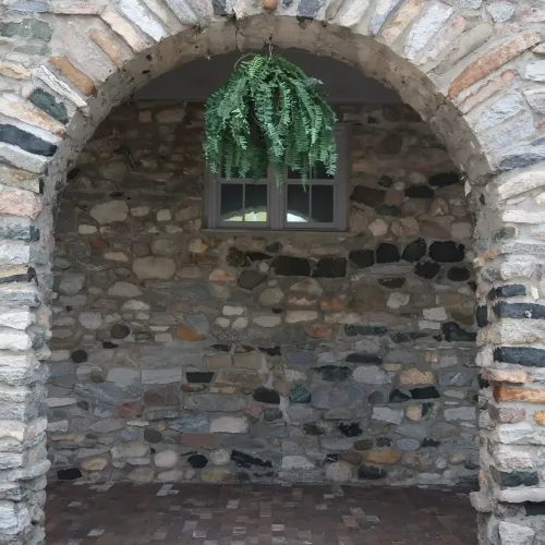 A basket hanging with greenery on a stone archway in a courtyard at Castle Farms.