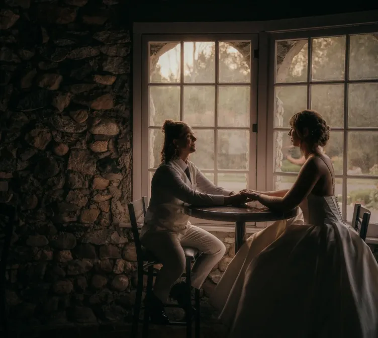 A couple sits at a table near windows in the dark tavern at Castle Farms.