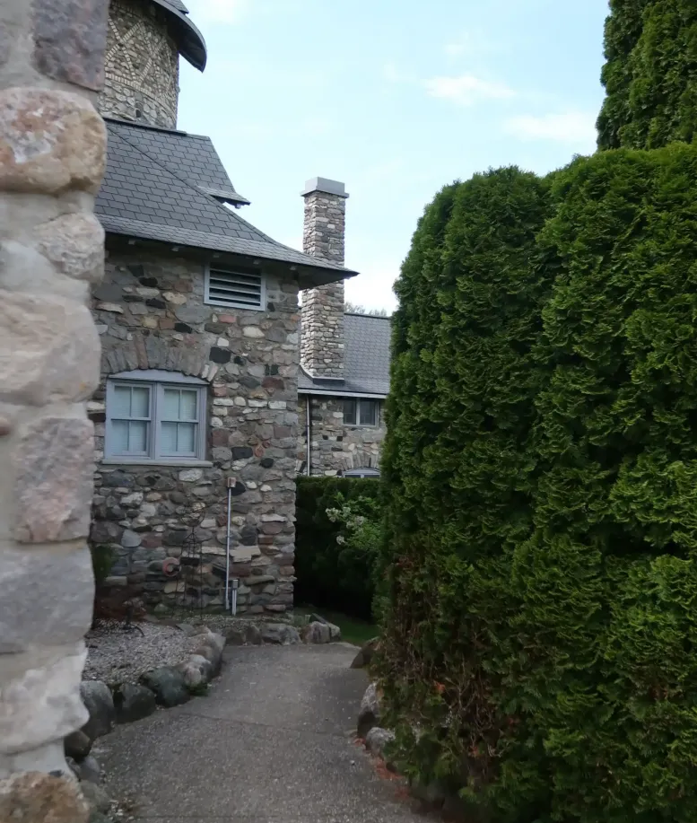 A gravel path winding through the stone buildings and shaped hedges of Castle Farms.