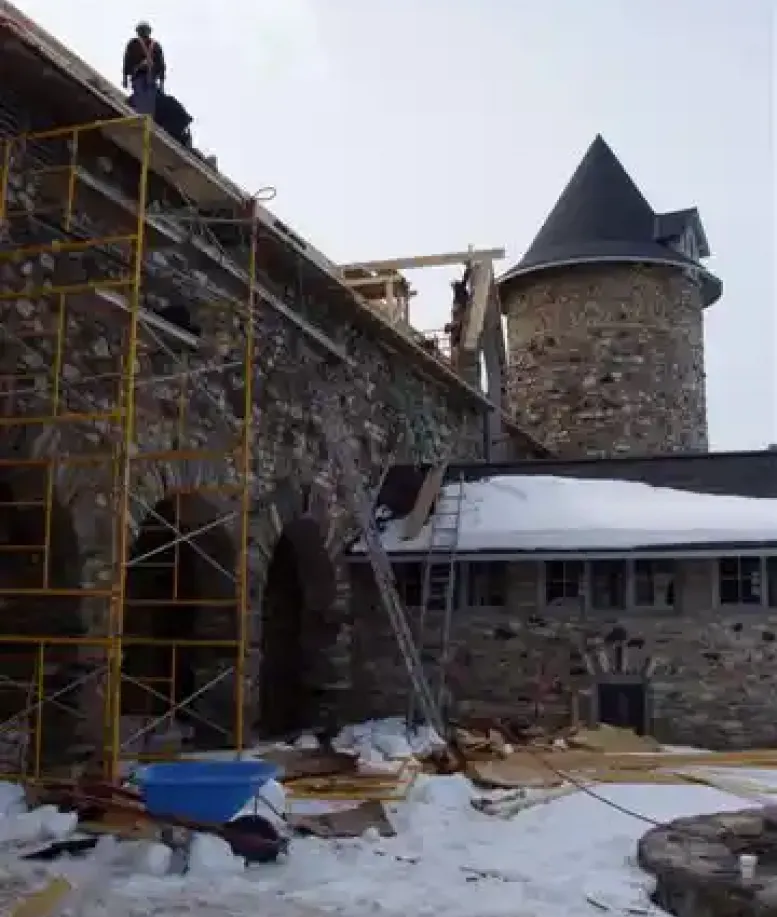 A building with scaffolding covered in snow during restoration at Castle Farms.