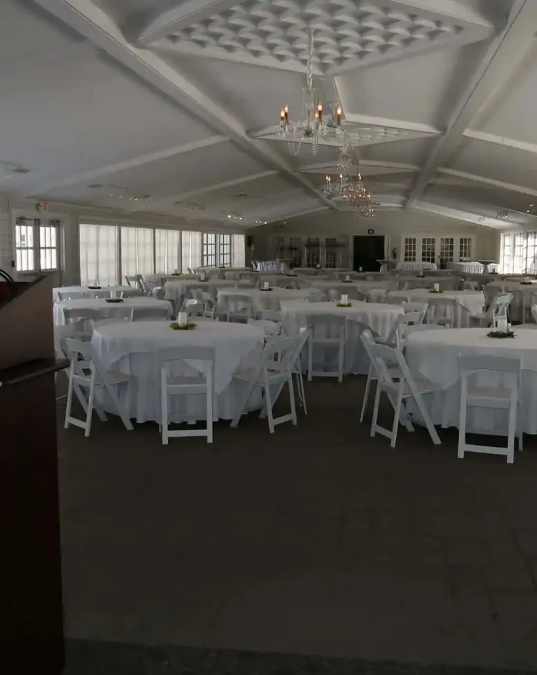 Event space with tables, chairs, and a podium at Castle Farms. 
