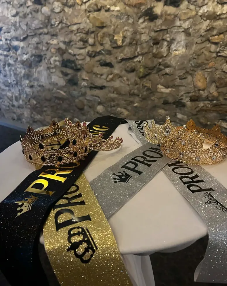 Crowns and sparkly prom sashes on a table at Castle Farms.