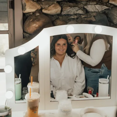 A bride getting her hair done in the reflection of a  mirror at Castle Farms.