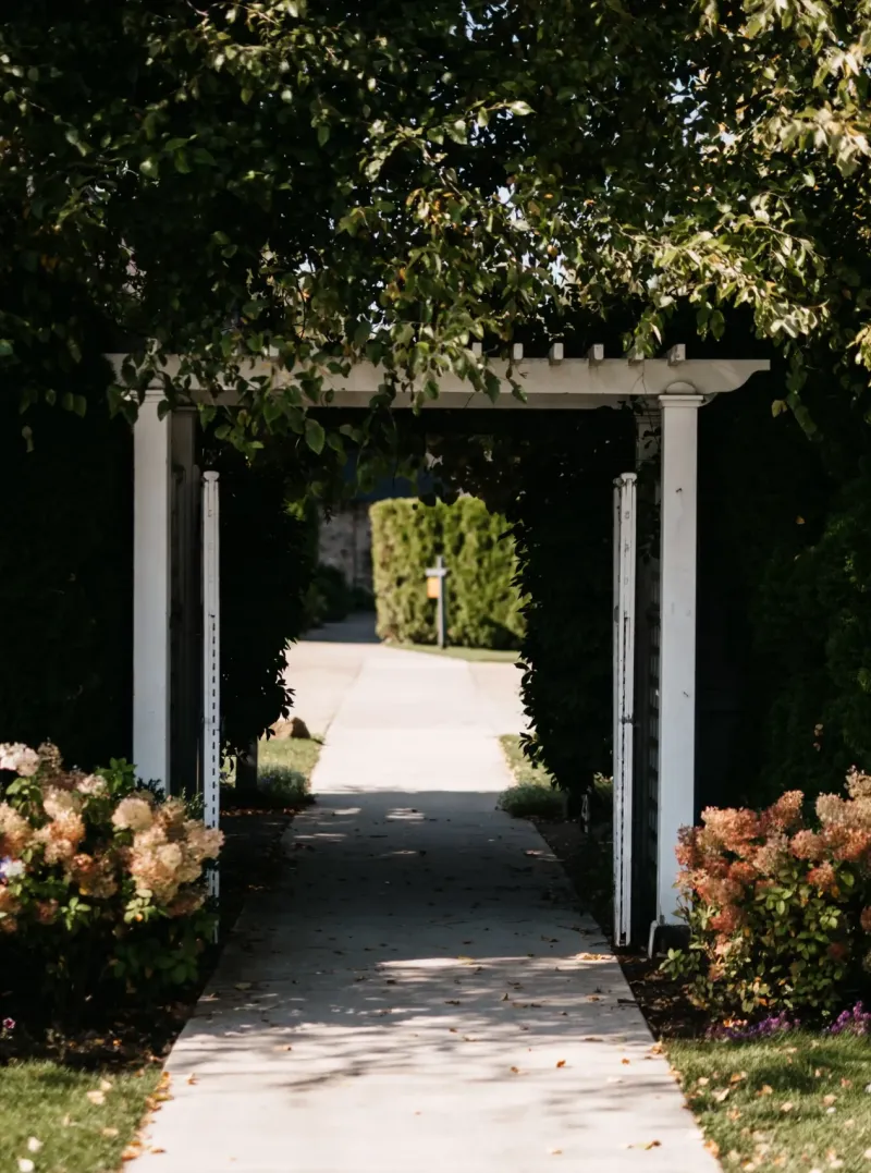 A sidewalk underneath a wooden garden arch surrounded by a hedge on the grounds of Castle Farms.
