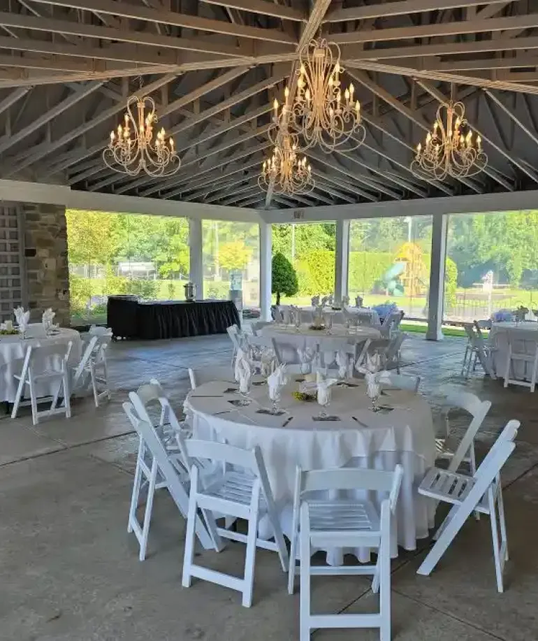 White tables and chairs in the Rose Pavilion at Castle Farms.