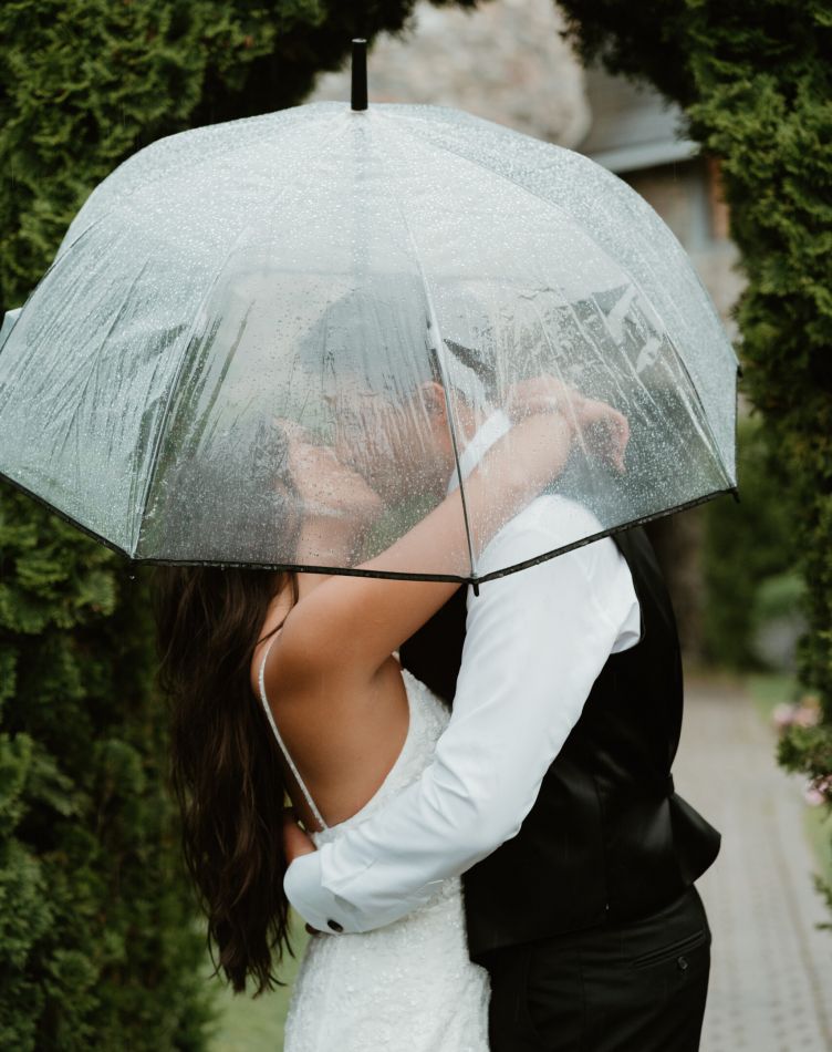 A bride and groom kissing by a window in the King's Chapel at Castle Farms.