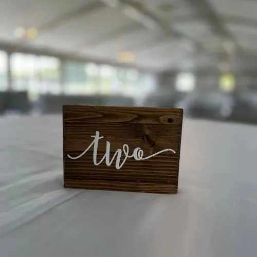 A wooden table marker reading "two" on a table at Castle Farms.