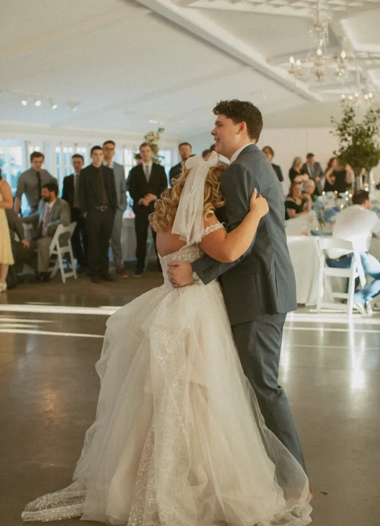 A bride and groom dancing in a white reception hall at Castle Farms.