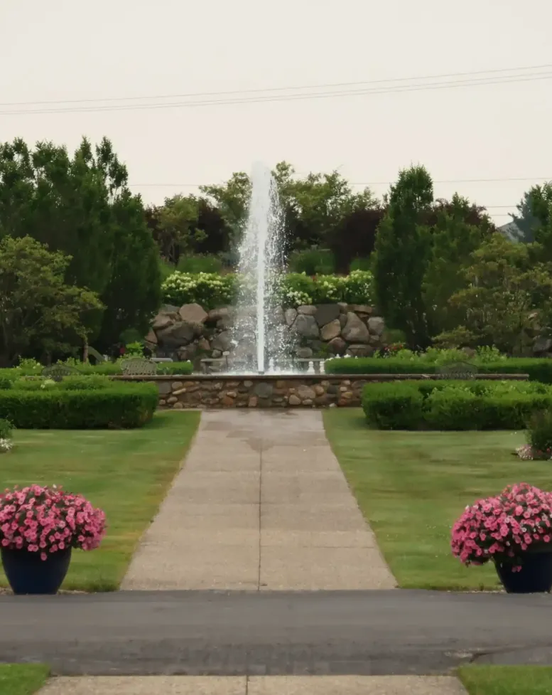 A water fountain and a sidewalk n the grounds of Castle Farms.