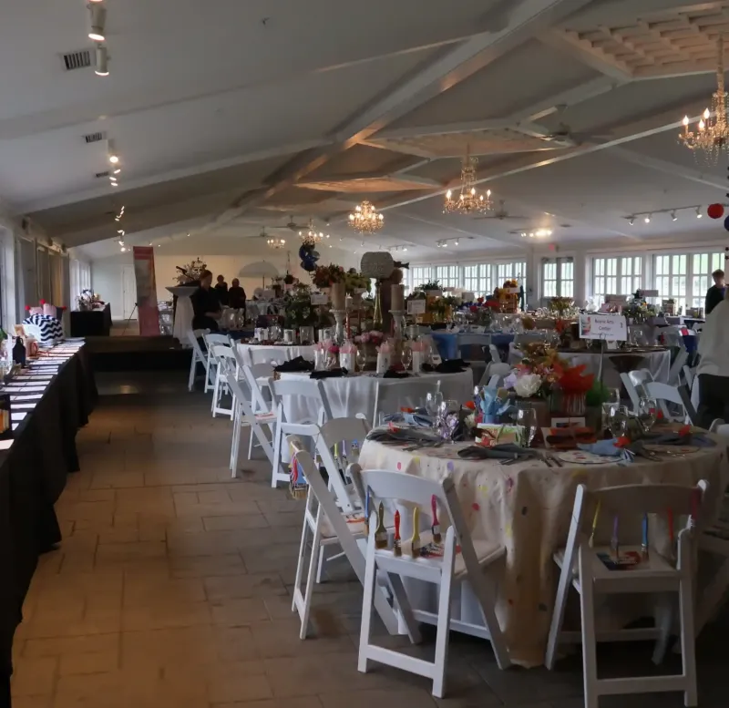 Tables with fun decorations and long black tables at a corporate event in a reception room at Castle Farms. 
