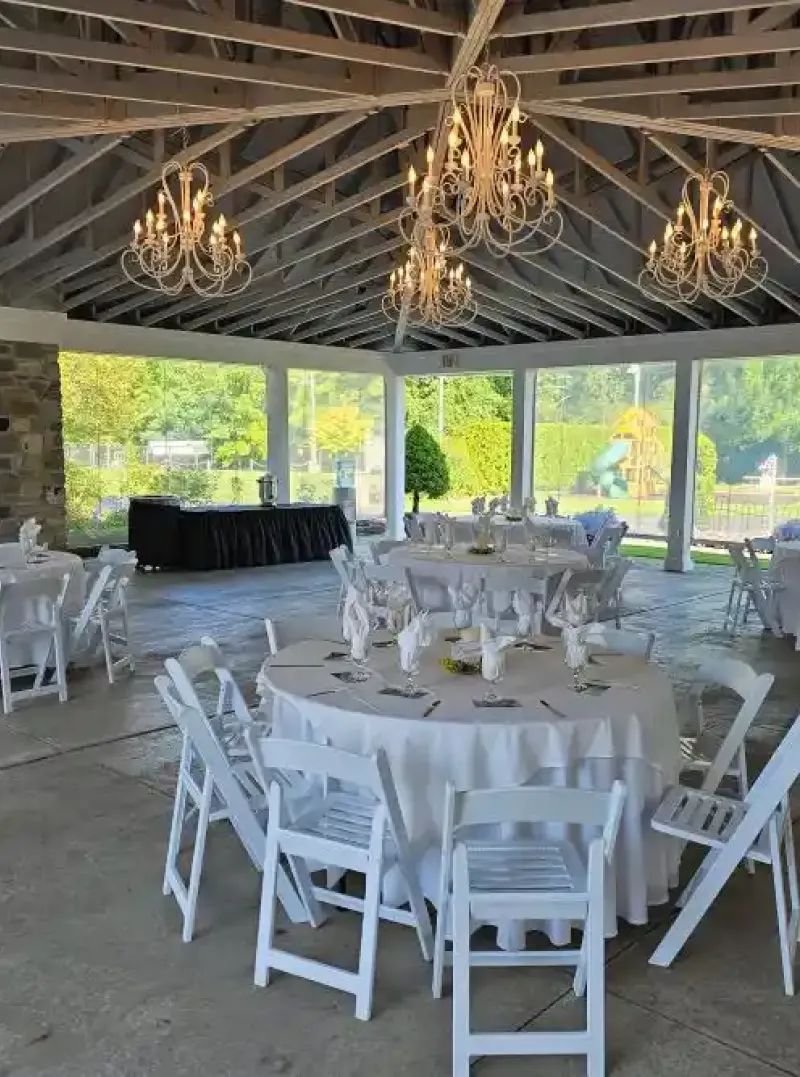 White tables and chairs in the Rose Pavilion at Castle Farms.