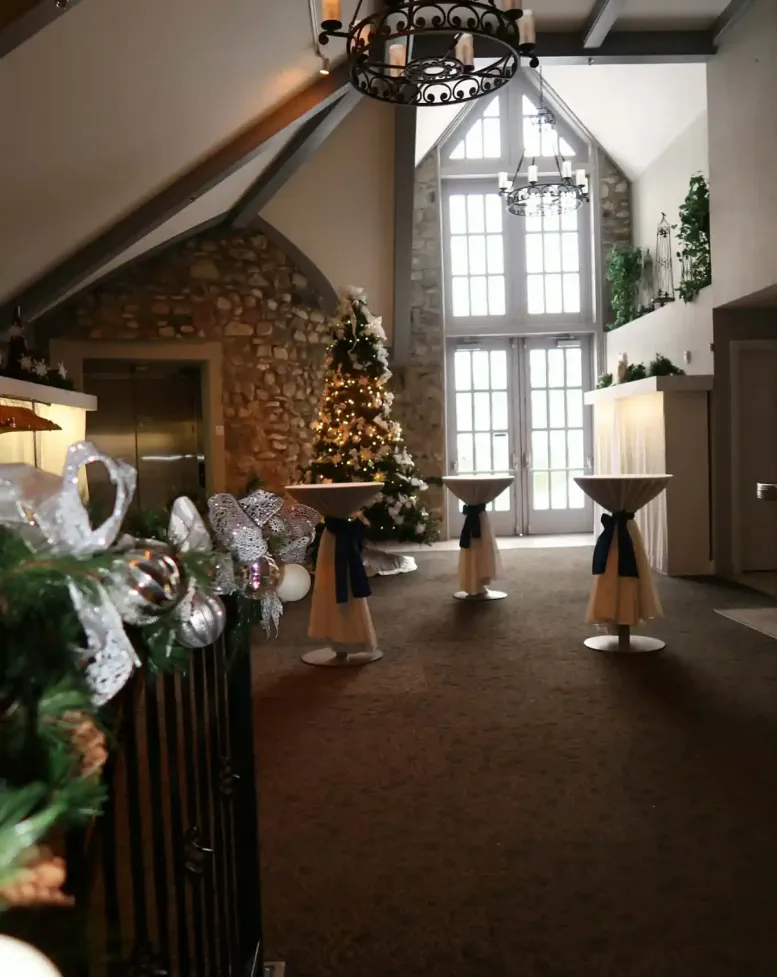 Christmas trees and tall tables at a holiday party at Castle Farms.