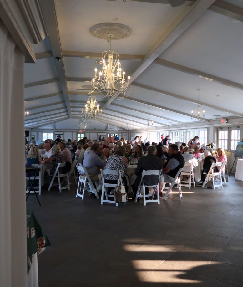 People gathered at tables in an event space at Castle Farms.