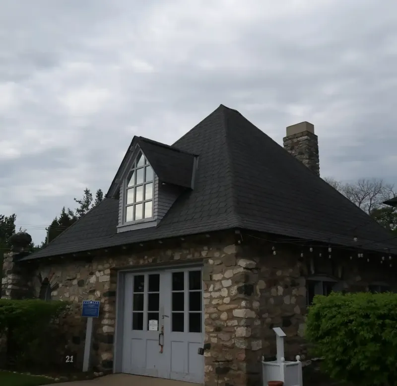 A building with a paved sidewalk leading to doors on a cloudy day at Castle Farms.