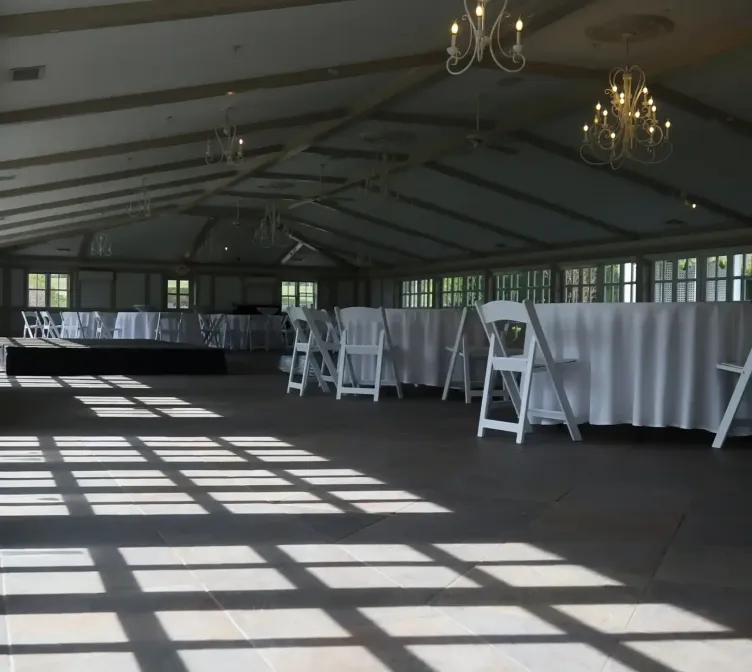 Sunlight pouring into an event space with tables and chairs at Castle Farms. 