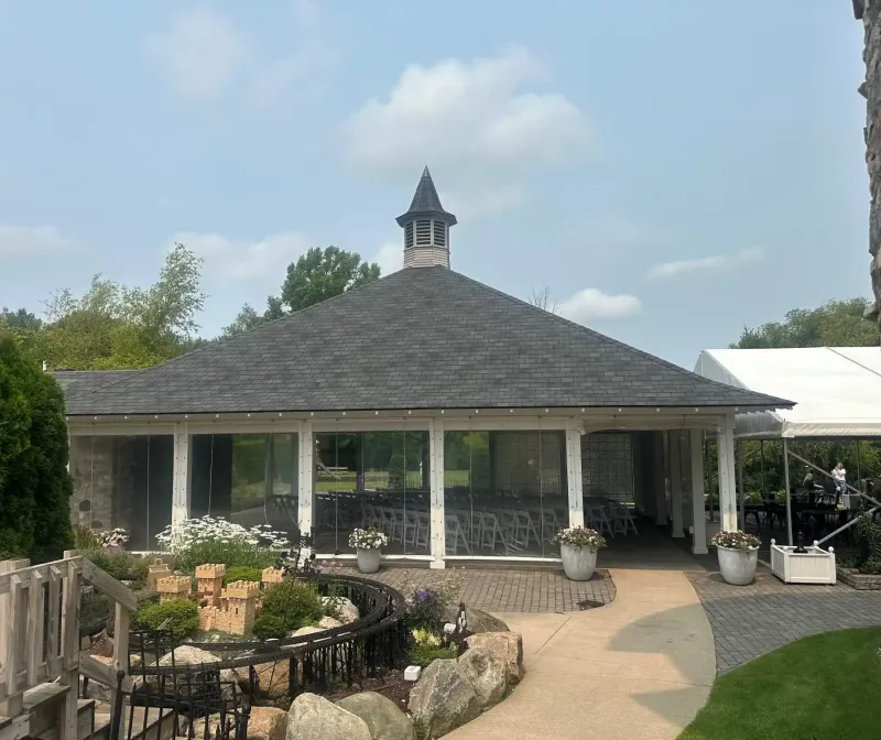 The Rose Pavilion next to a garden on a sunny day at Castle Farms.