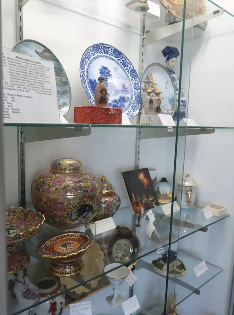 A glass case of old pots and ceramic plates at a museum in Castle Farms.