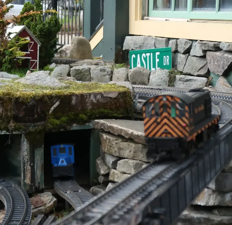 A toy train on a miniature train track set at Castle Farms.