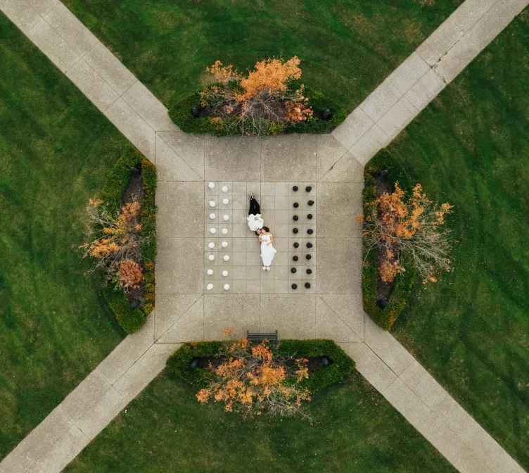 An aerial image of a bride and groom lying in the gardens of Castle Farms.