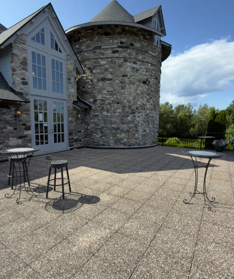 A stone balcony with tall tables next to a castle tower at Castle Farms. 