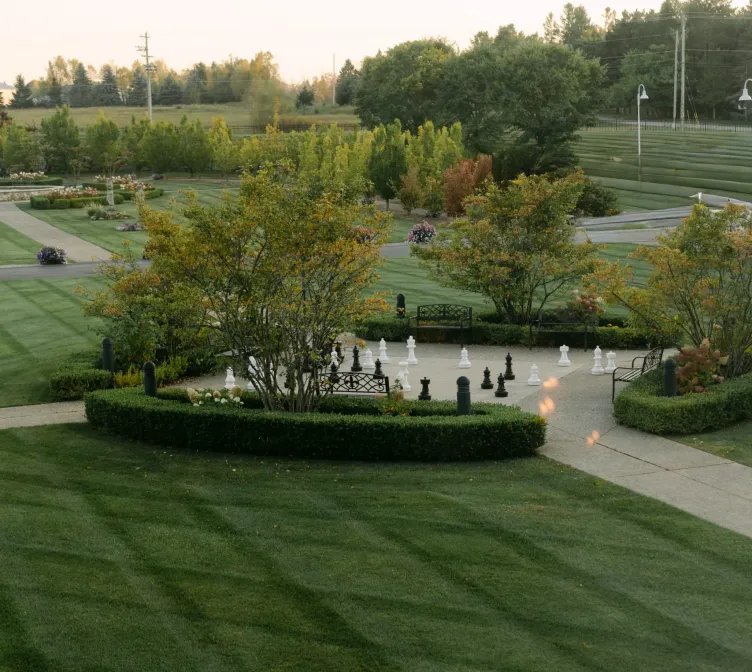 View of a green lawn and a giant chess game from a window at Castle Farms.