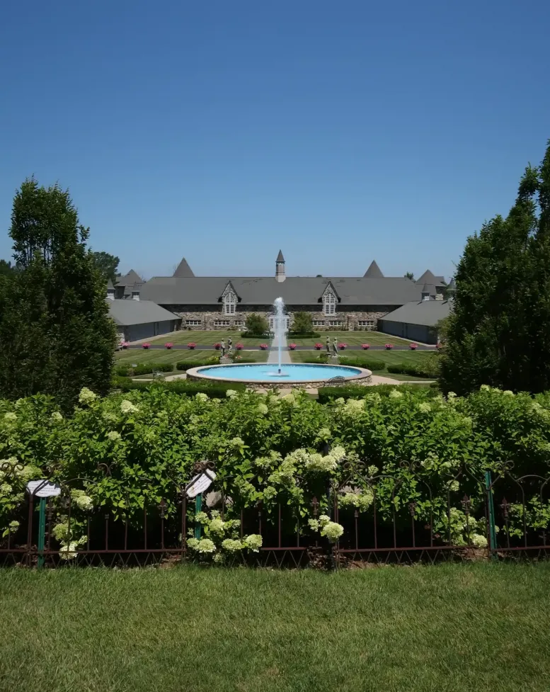  A fountain and flower bushes under a clear blue sky at Castle Farms.