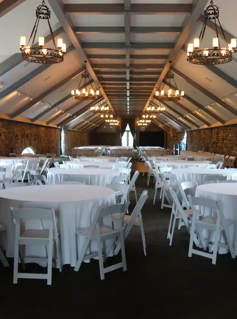 A great hall with round tables and chairs at Castle Farms